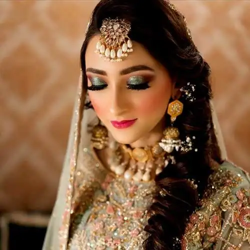 "Elegant reception makeup by Dolledup By Tooba, featuring sophisticated eye makeup, glowing skin, and a flawless, timeless look."